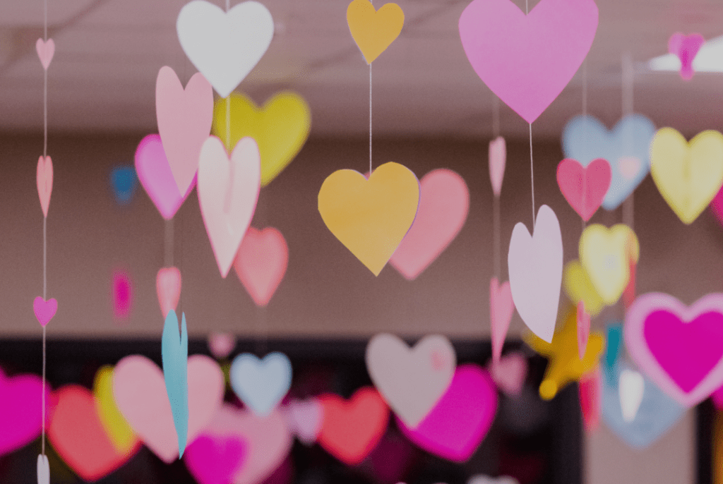 Colorful paper hearts hanging from the ceiling, symbolizing the celebration of love and self-love on Valentine's Day.