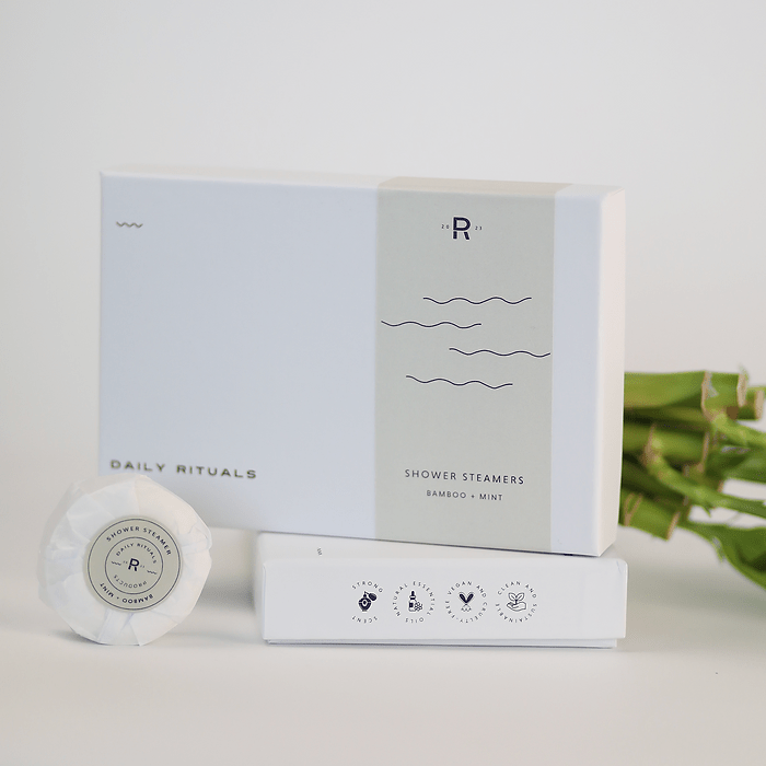 Box of 'Daily Rituals' shower steamers in bamboo and mint scent. The set includes individually wrapped steamers and a clean, minimalist design with a focus on natural ingredients and self-care.