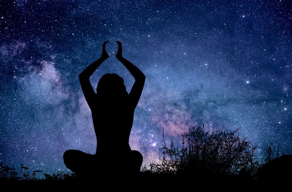 Woman silhoutted against night sky thinking about her future and her horoscope