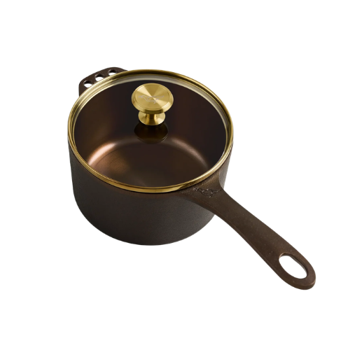 Black saucepan from Smithey with a gold rim and a brass knob on the lid, featuring a long handle.