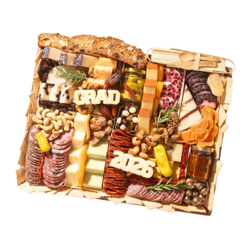A decorative charcuterie board featuring an assortment of cheeses, cured meats, nuts, fruits, and snacks. The board is arranged with the words 'GRAD' and '2026' made of cheese, along with elegant garnishes like rosemary.