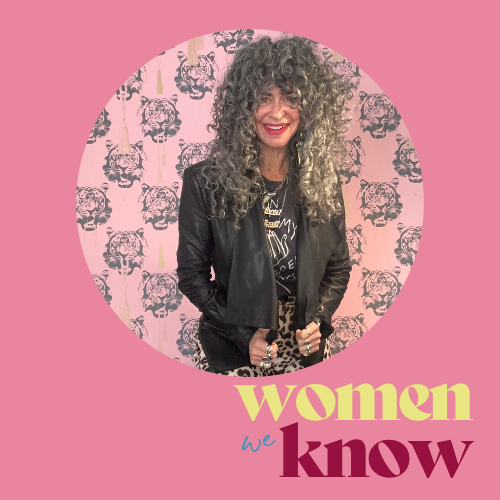 A woman with curly gray hair wearing a black jacket and a graphic shirt stands against a pink background featuring tiger patterns. The text 'women we know' is displayed at the bottom.