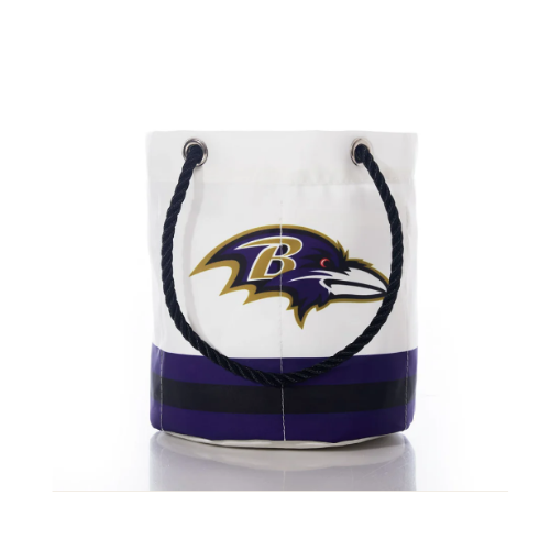 A white bucket bag featuring the Baltimore Ravens logo, with a purple and black striped bottom and black rope handles.