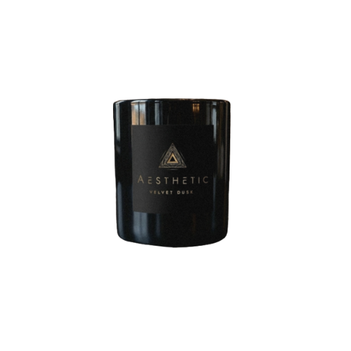 A black candle jar labeled 'AESTHETIC' with a geometric logo and 'VELVET DUSK' printed on it.