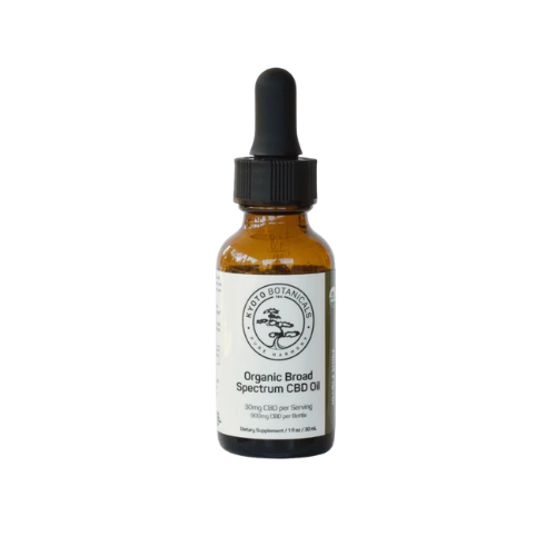 A brown glass bottle of Kyoto Botanical's organic broad spectrum CBD oil with a dropper top, labeled with dosage information and the brand name.