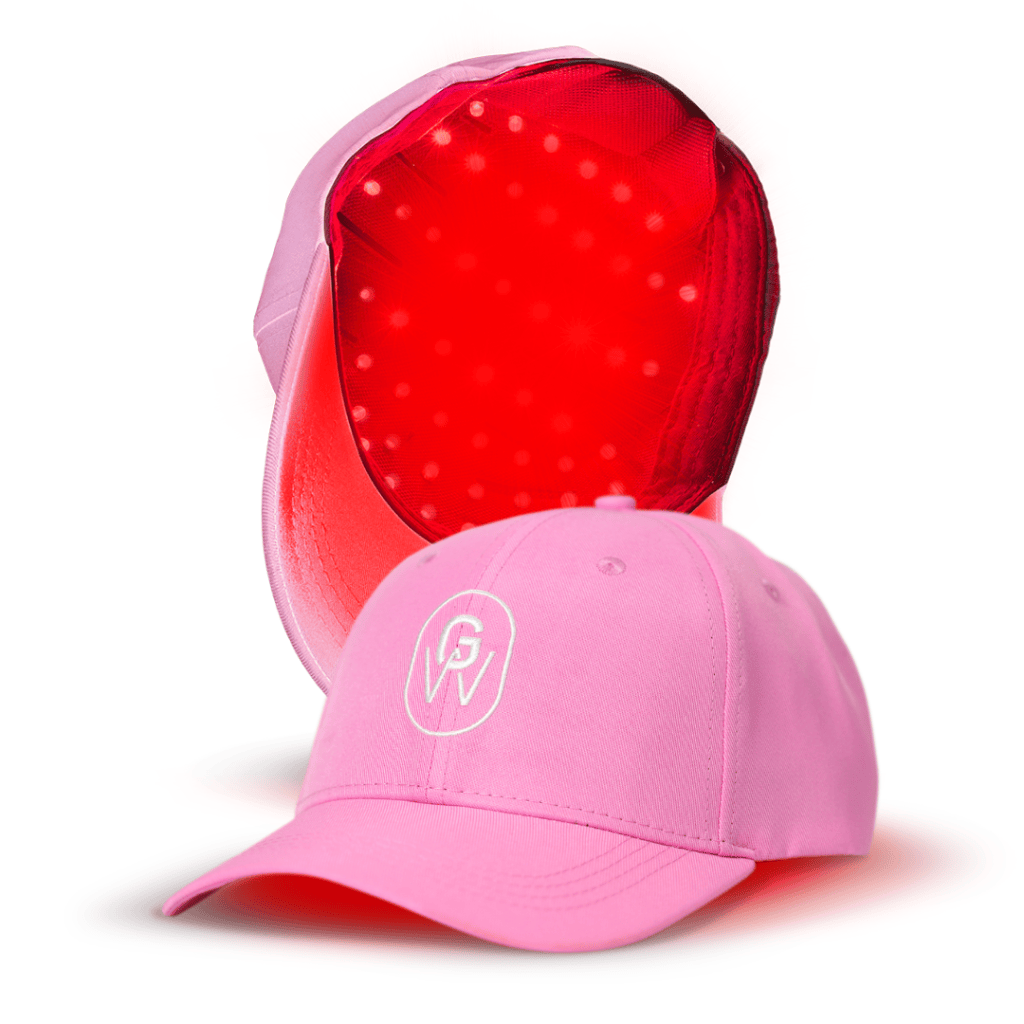 A pink GroWell wearable red light therapy cap with a logo on the front, positioned next to its interior showing a bright red lining with a dotted texture.